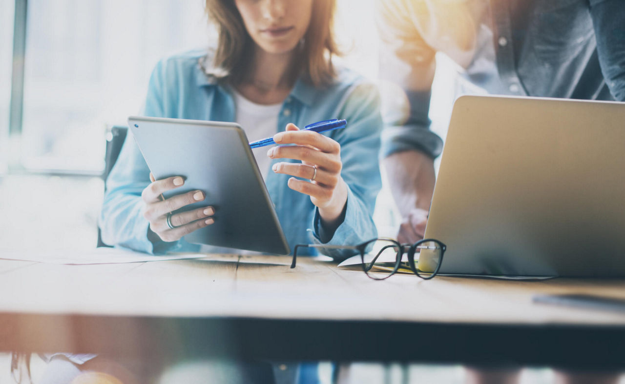 Frau erklärt Mann am Tablet Banking-Lösungen