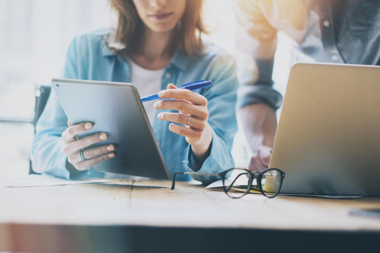 Frau erklärt Mann am Tablet Banking-Lösungen