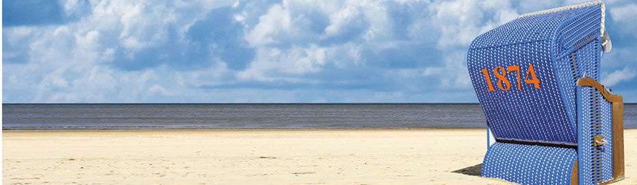 Ein blauer Strandkorb steht an einem Sandstrand mit Meerblick