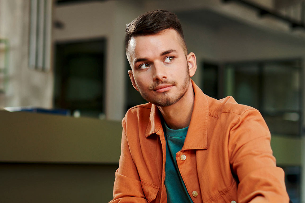 Junger Mann sitzt am Tisch