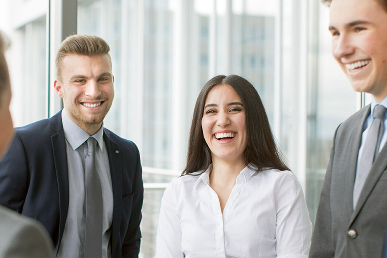 Mehrere Personen stehen in einer Guppe und lachen