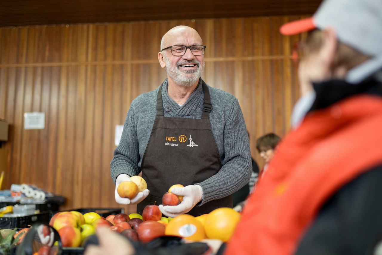 Ein Mann der Obst in den Händen hält.