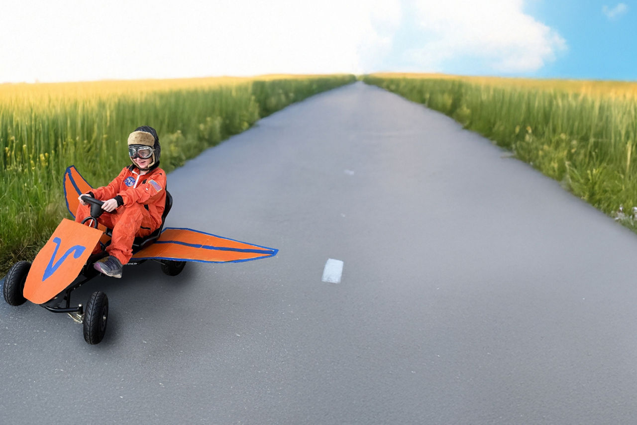 Ein Kind auf einem Go- Kart auf einem Feldweg. 