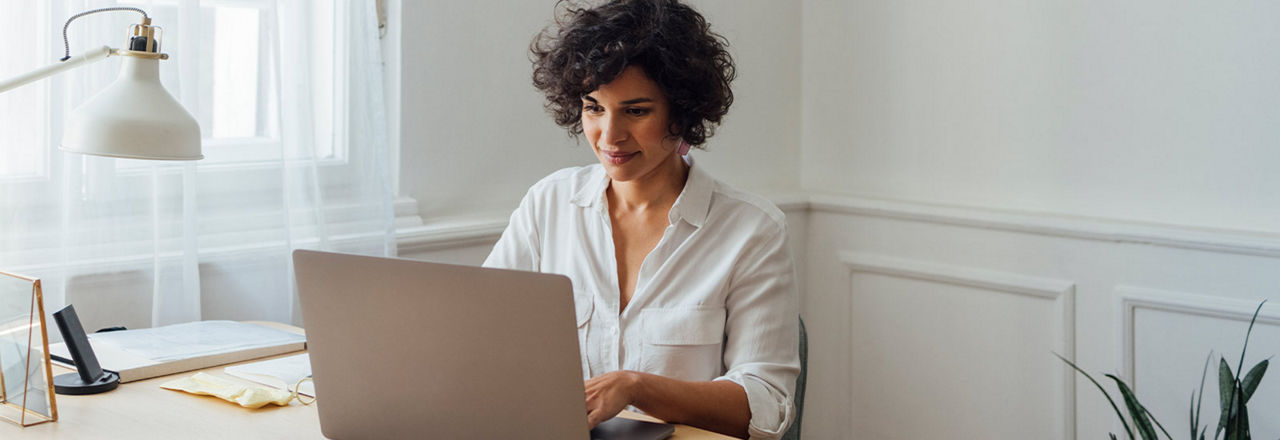 Frau sitzt vor Laptop