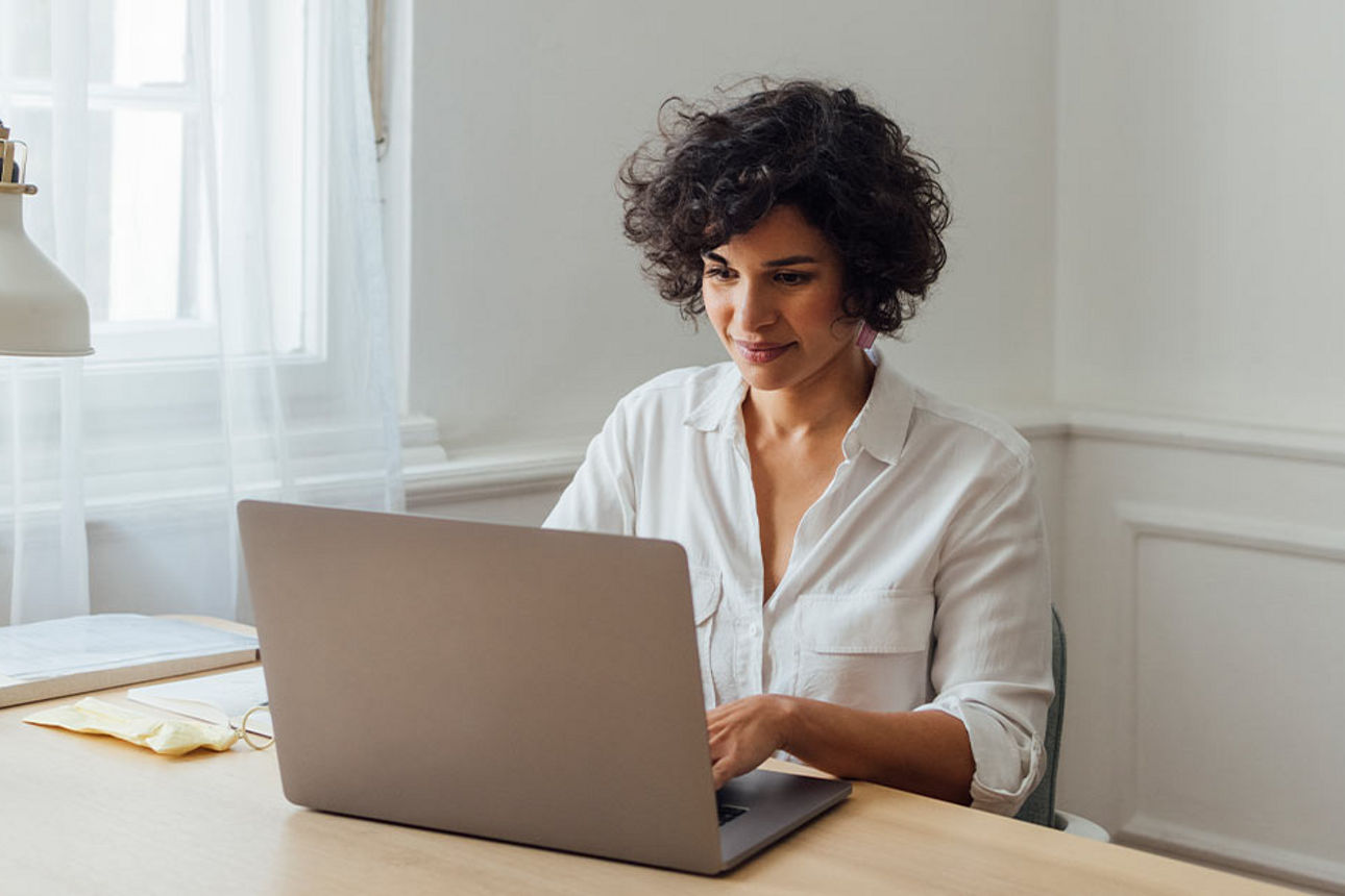 Frau sitzt vor dem Laptop
