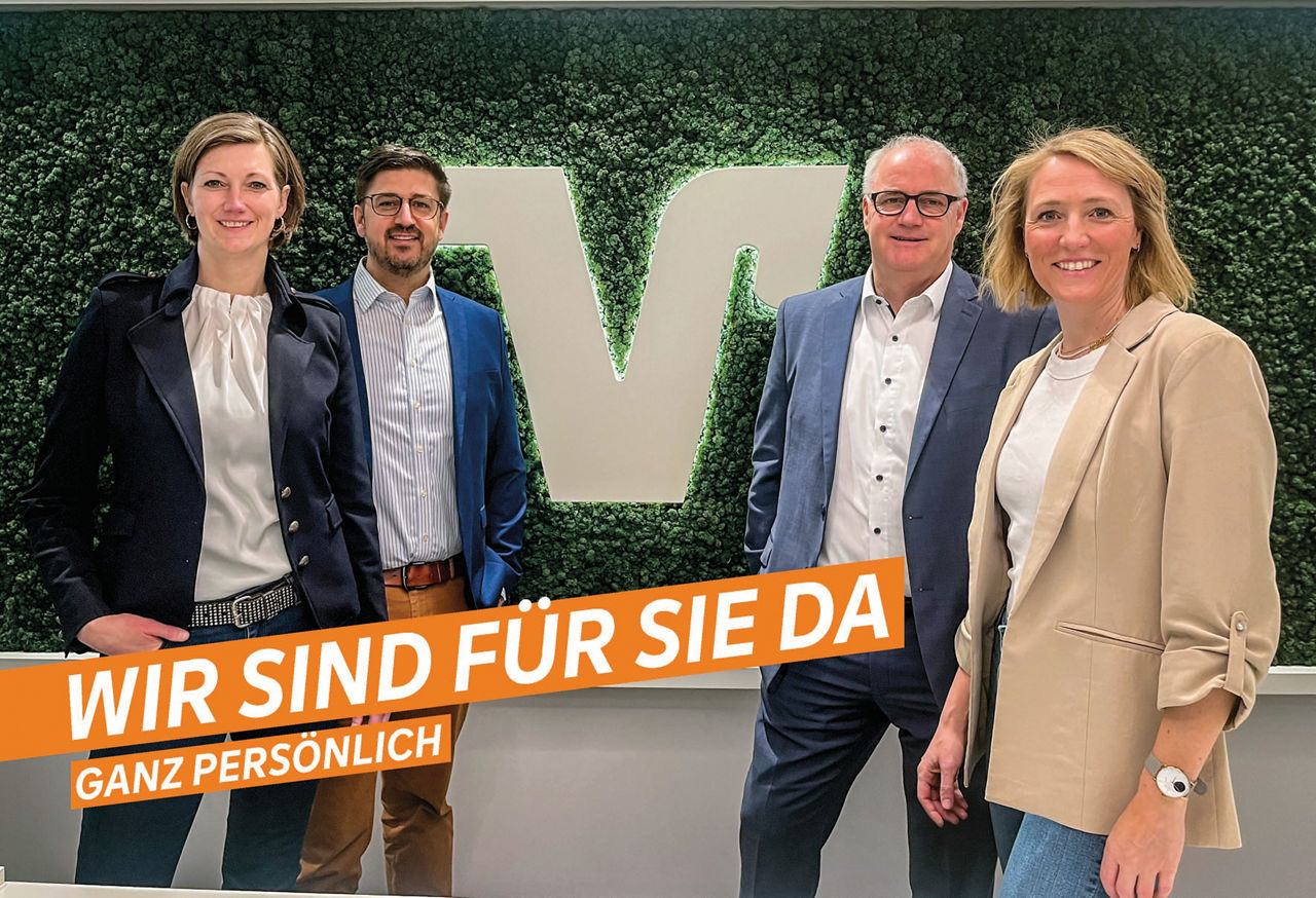 Vier Personen stehen vor einer grünen Wand - Wir sind für Sie da ganz persönlich