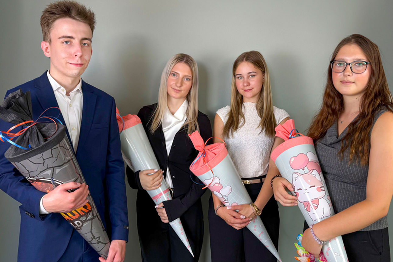 Unsere vier neuen Auszubis mit Zuckertüten an ihrem ersten Ausbildungstag