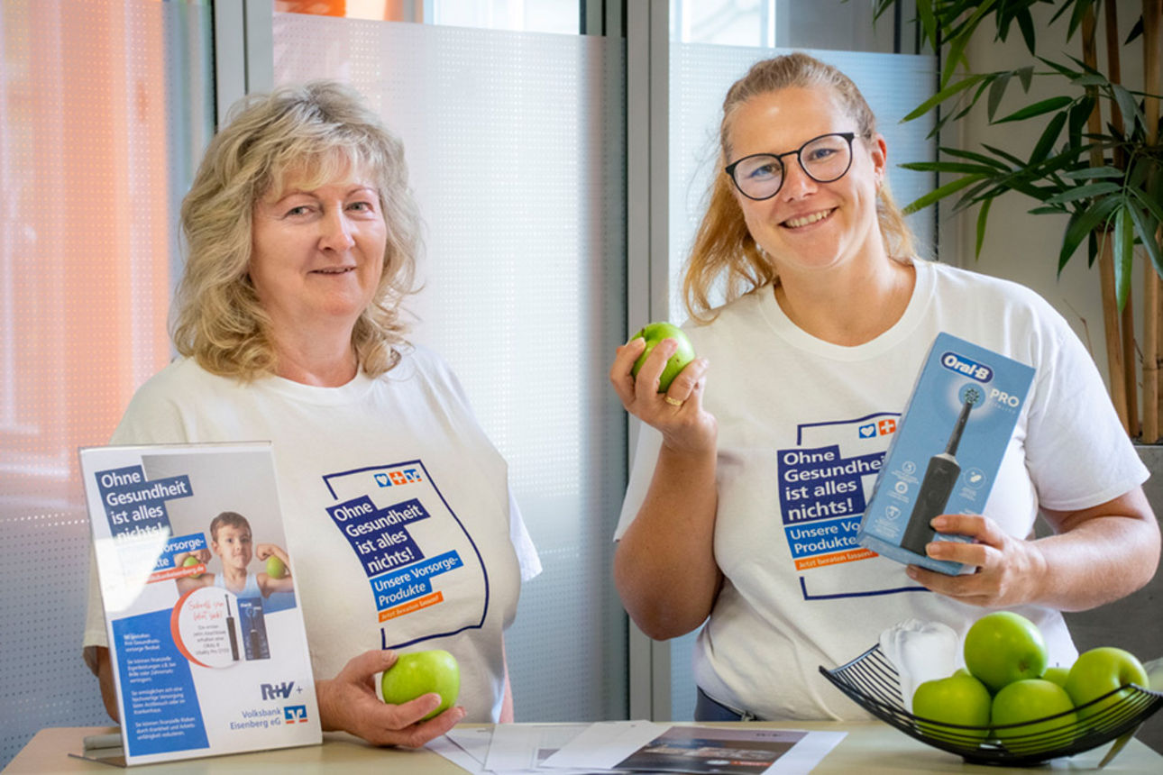 Unsere beiden Kundenberaterinnen mit Gesundheitswoche-Shirts grüne Äpfel haltend