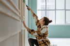 Junge Frau streicht ein Wand