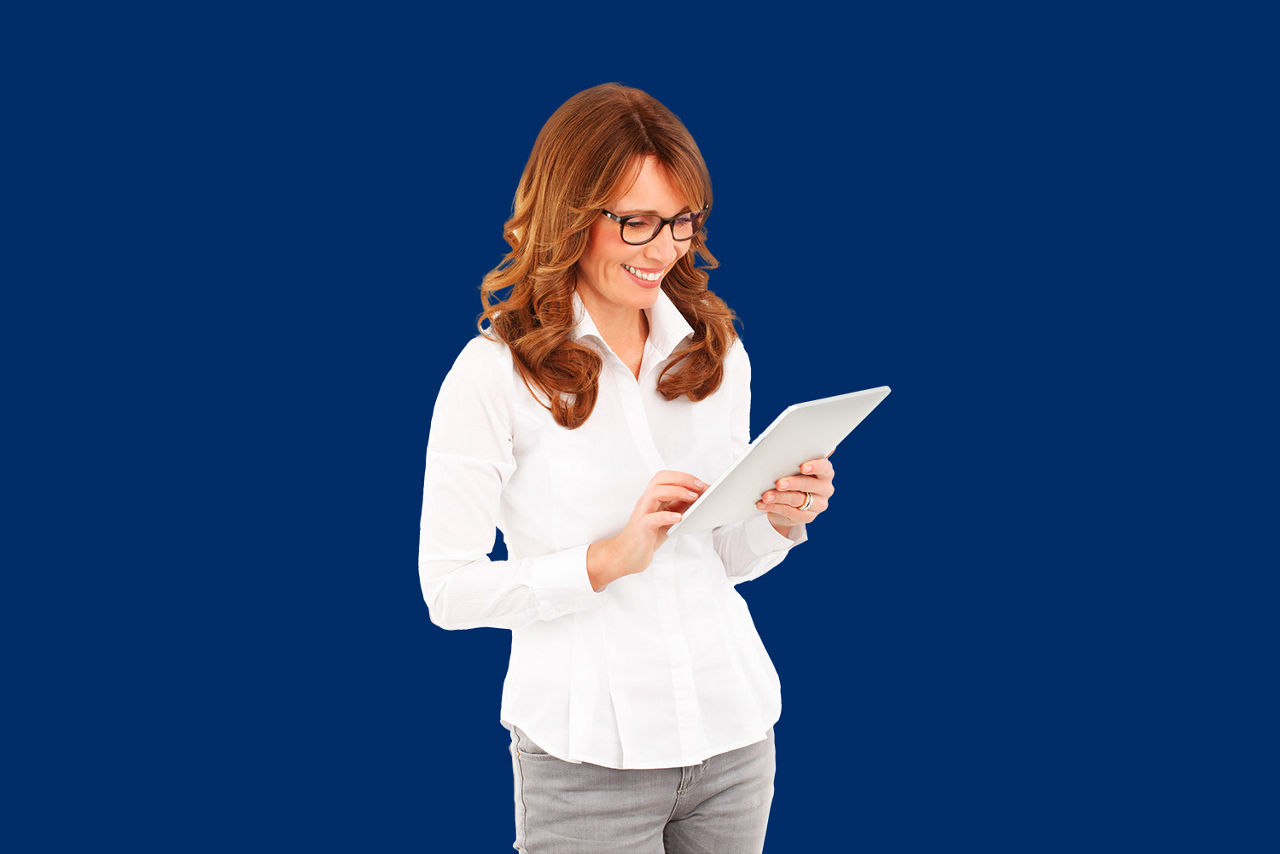 Frau steht mit ihrem Tablet vor einer blauen Wand