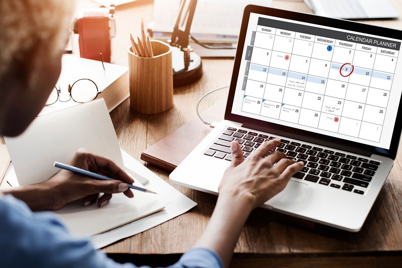 Person schaut in den digitalen Kalender am Laptop