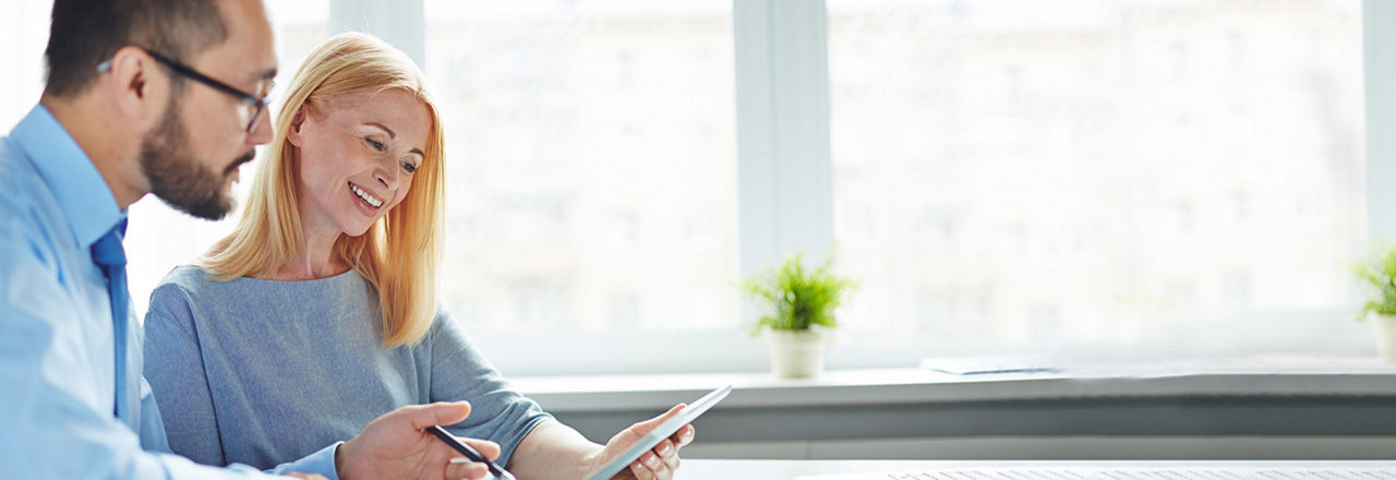zwei Menschen schauen auf ein Tablet und buchen gemeinsam einen online Termin