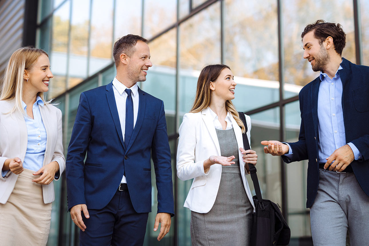 Zwei Frauen und zwei Männer lächeln sich zu.