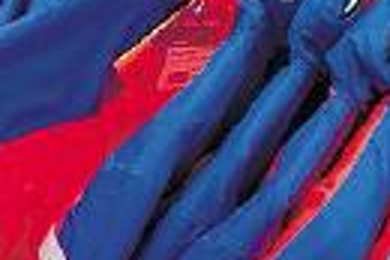 Neue blaue und rote Arbeitskleidung auf Kleiderbügeln