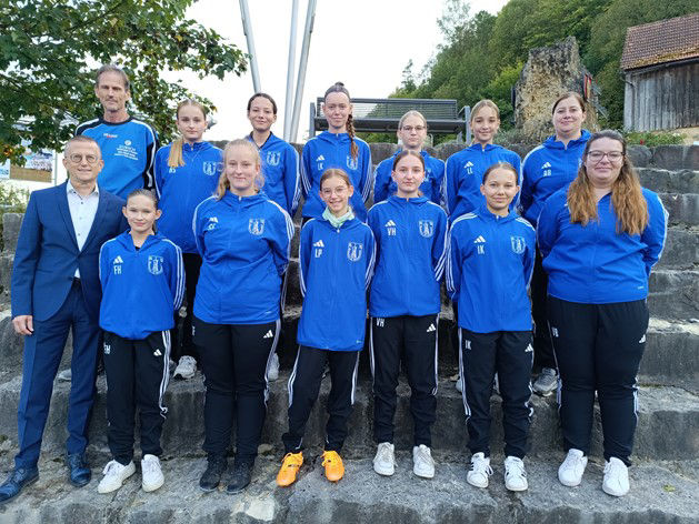 Ein Mannschaftsfoto von jungen Fußballerinnen, vereint in Blau.