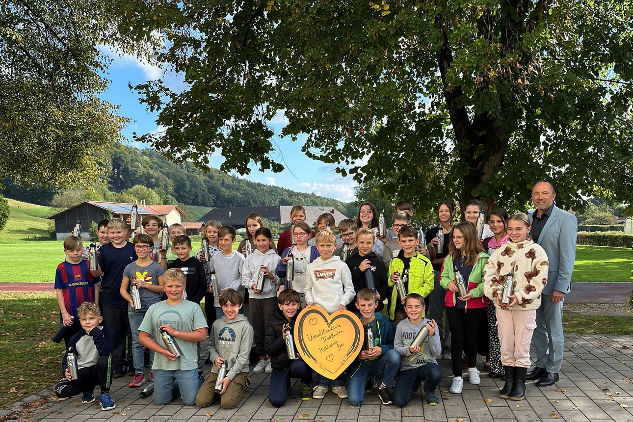 Kinder mit Trinkflaschen auf Pausenhof 