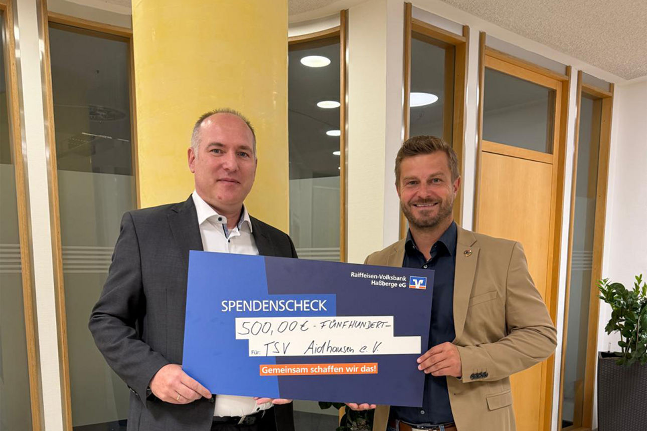 Alexander Rauschert von der Raiffeisen-Volksbank Haßberge eG übergibt die Spenden an den TSV Aidhausen