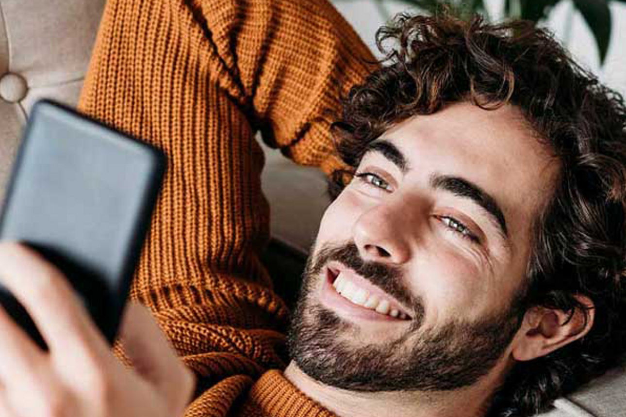 Sicherheit geht vor - Mann hält ein Smartphone in der Hand und lächelt