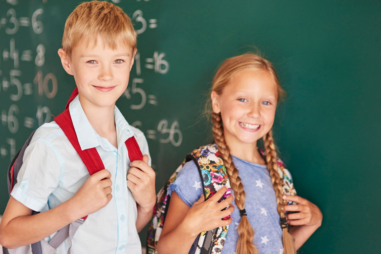 Junge und Mädchen vor einer Schultafel
