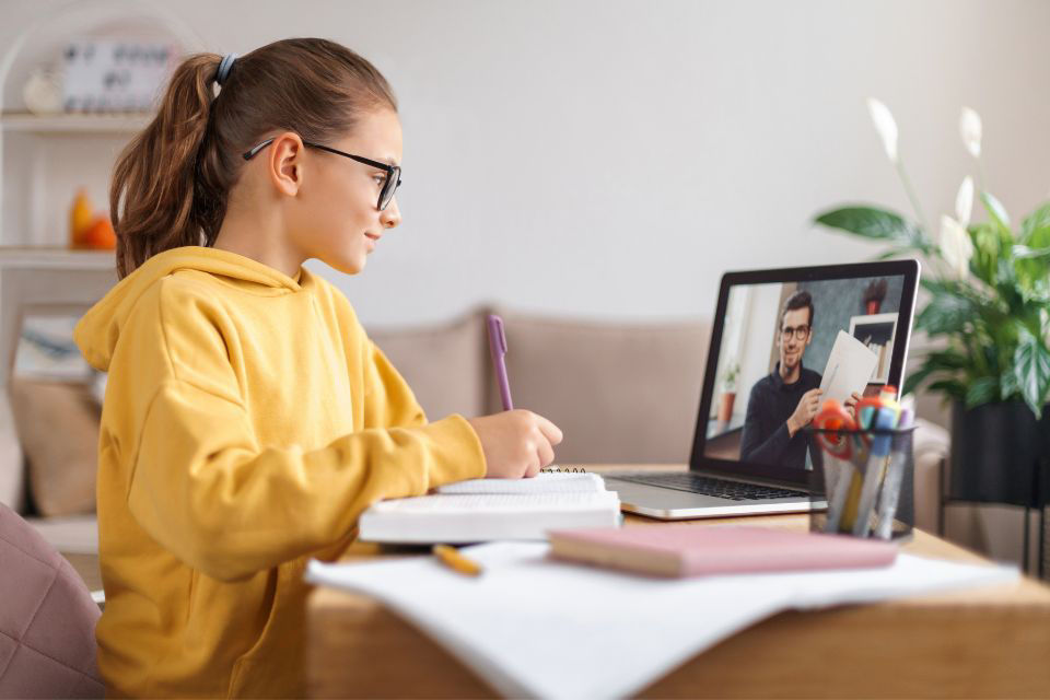 Junges Mädchen sitzt vor dem Laptop und nutzt ubiMaster