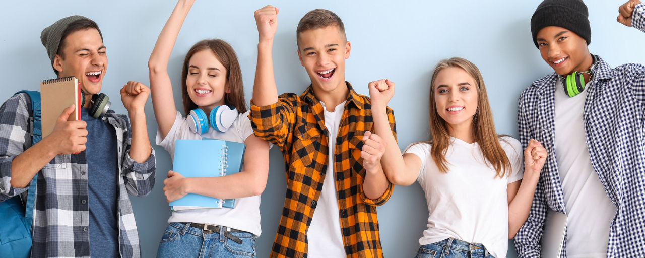 Schülerinnen und Schüler stehen jubeln vor einer Wand