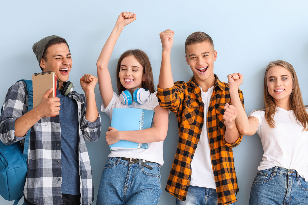 Schülerinnen und Schüler stehen jubelnd vor einer Wand