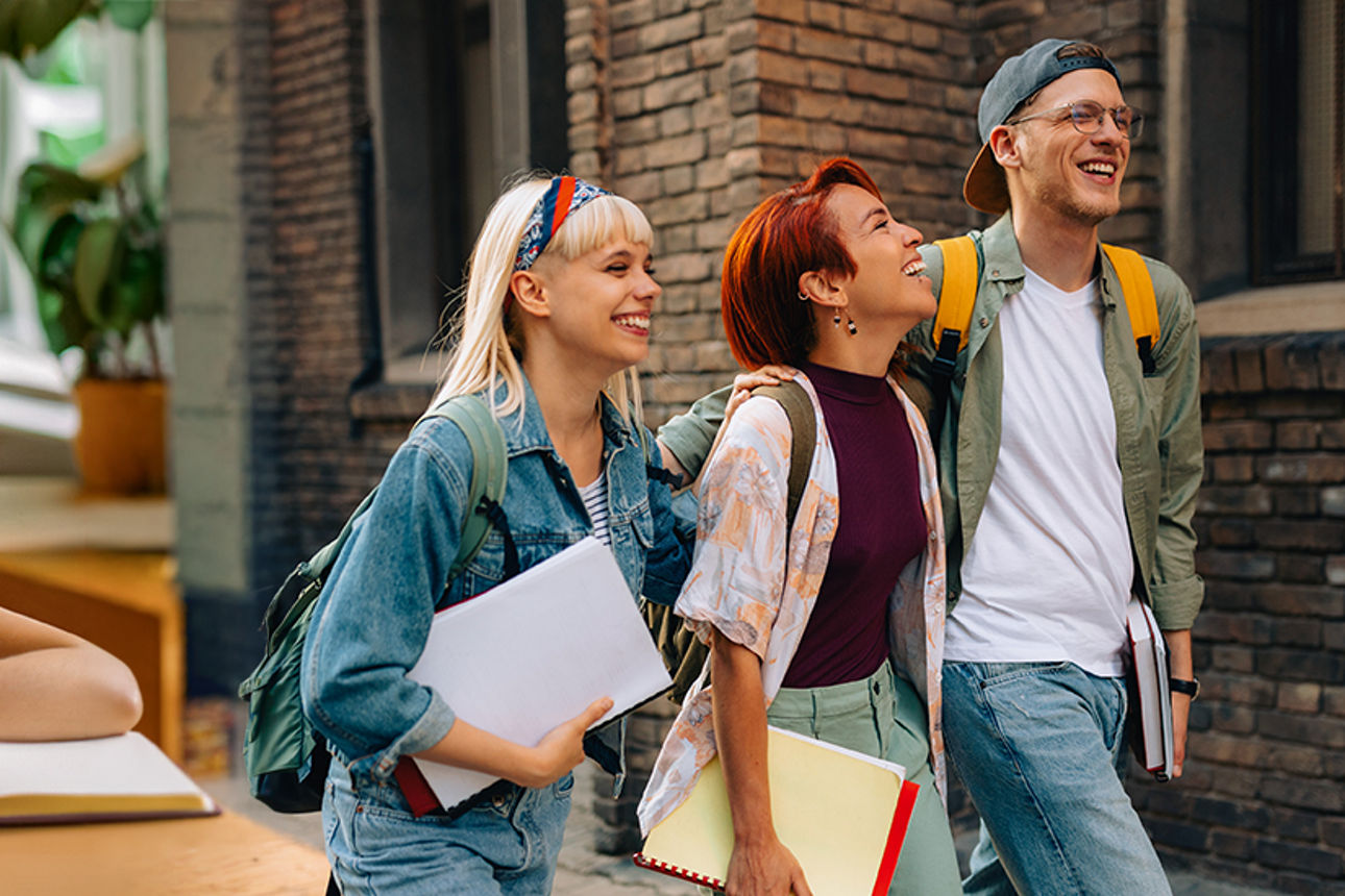 Schülerinnen und Schüler sitzen lächelnd in einem Klassenraum