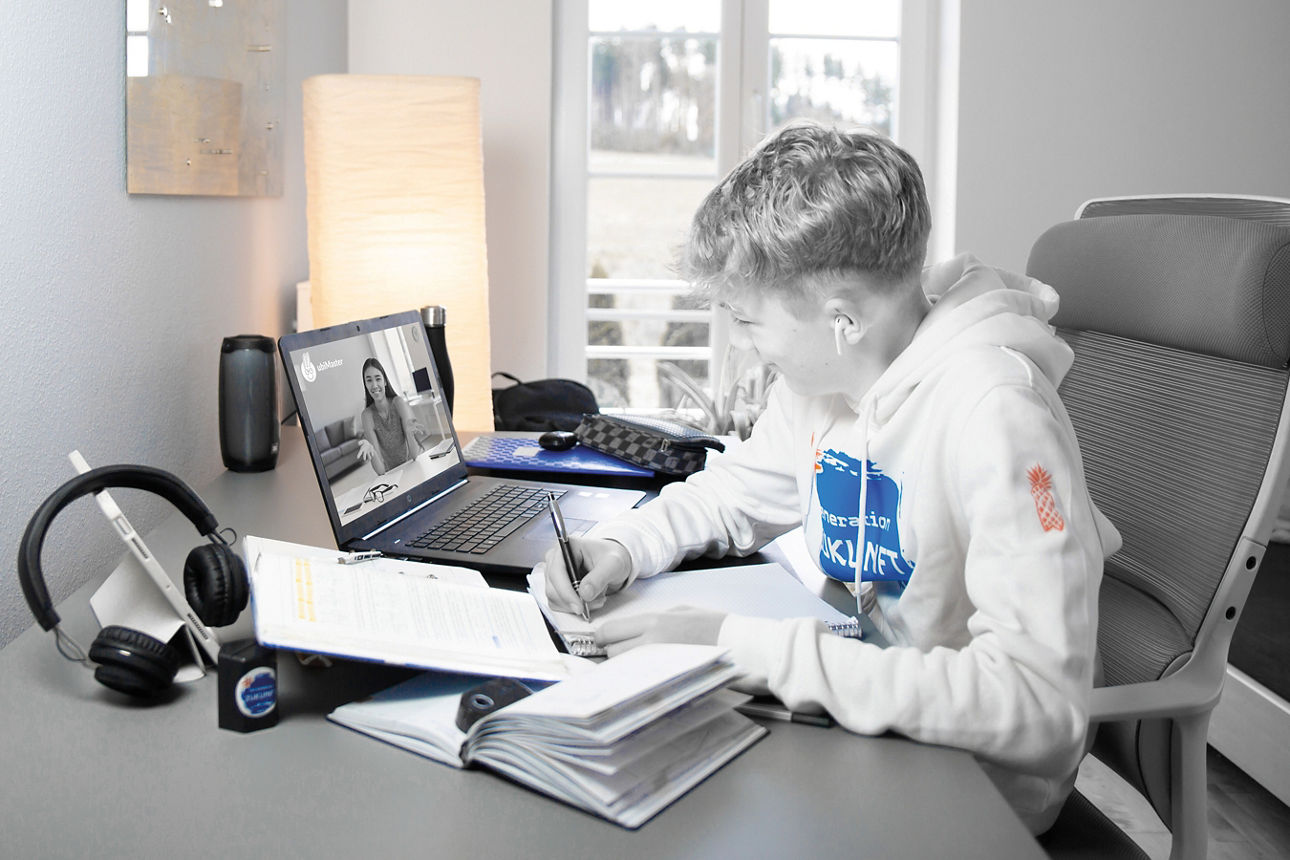 Ein Junge sitzt am Schreibtisch und lernt.