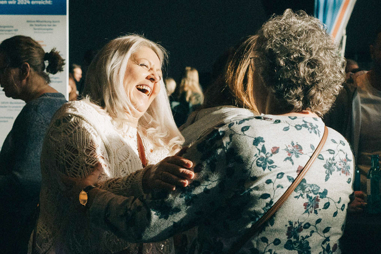 Mitarbeiter im Gespräch lachen miteinander auf einer Feier