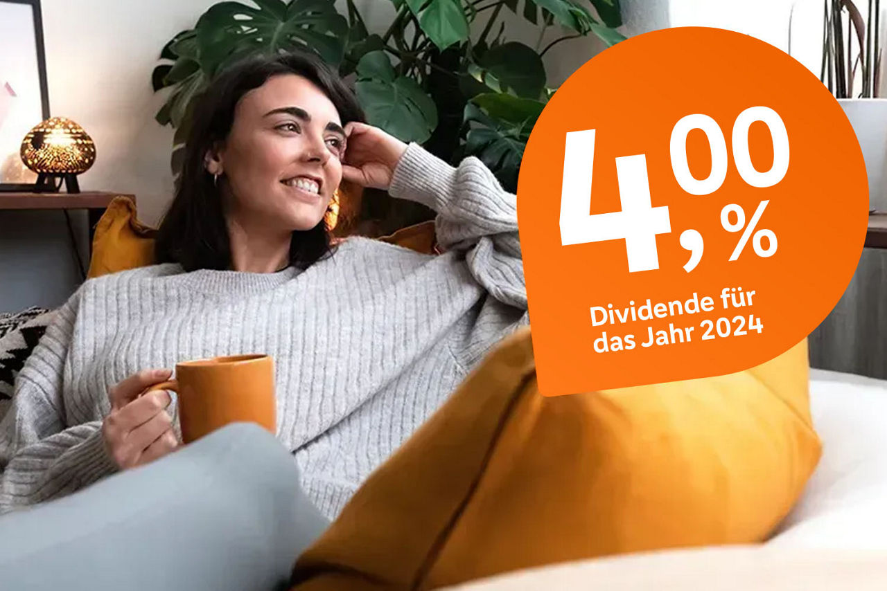 Junge Frau sitzt mit einer Kaffetasse auf ihrer Couch