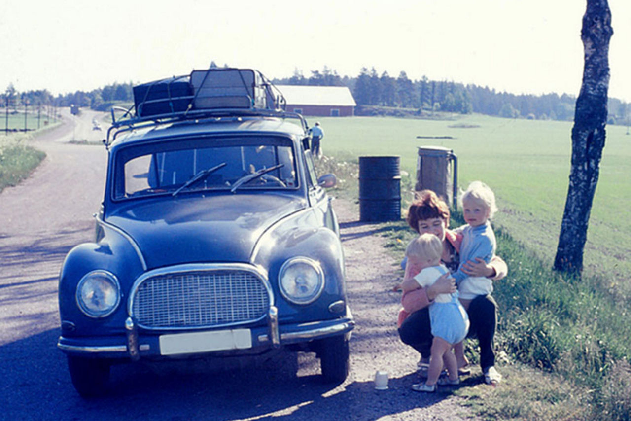 Oldtimer mit einer Mutter und ihren zwei Kindern am Straßenrand auf dem Feld