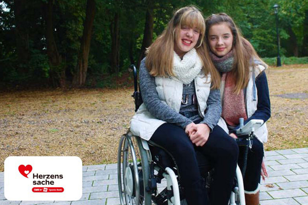 Freundin (im Rollstuhl) mit Freundin in einem Park
