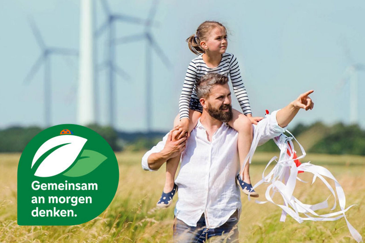 Vater mit Tochter auf dem Rüclen schauen in die Ferne auf dem Feld