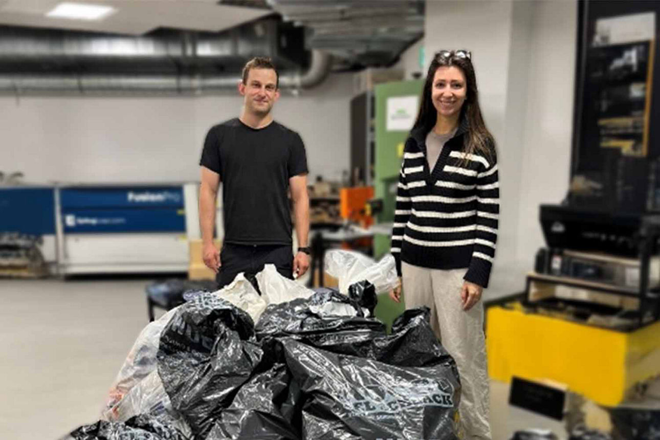 Zwei Mitarbeiter stehen vor einem Haufen von Müllsäcke