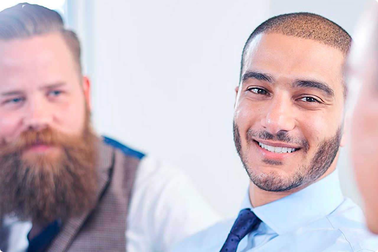 Ein junger Mann lächelt einen anderen Gesprächspartner an