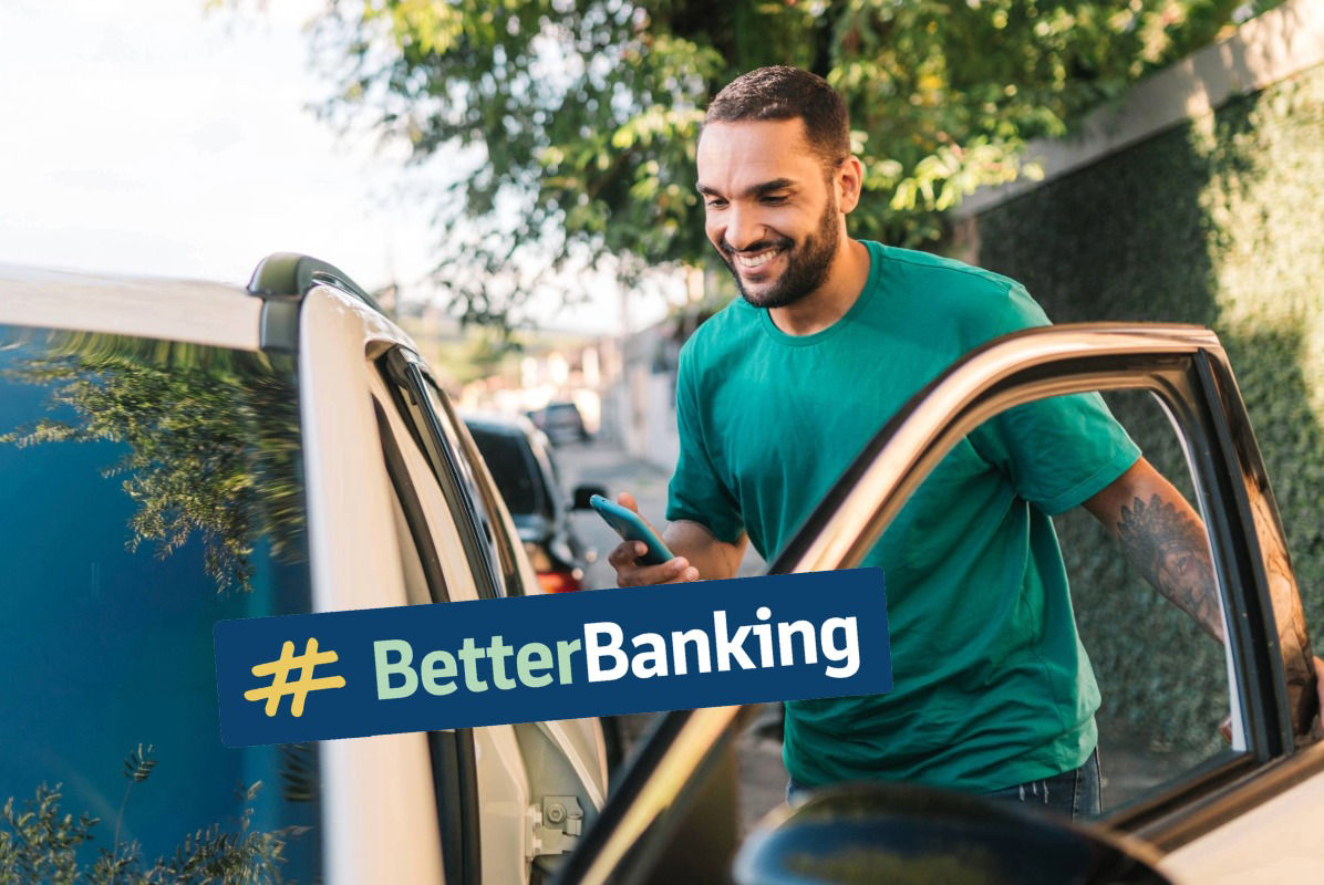 lächelnder junger Mann mit Handy in der Hand steigt in Auto