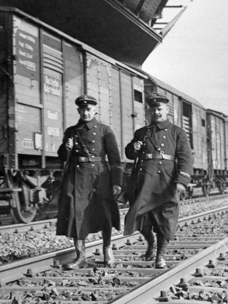 Historisches Bild zwei uniformierte Männer vor einem Eisenbahnwagong