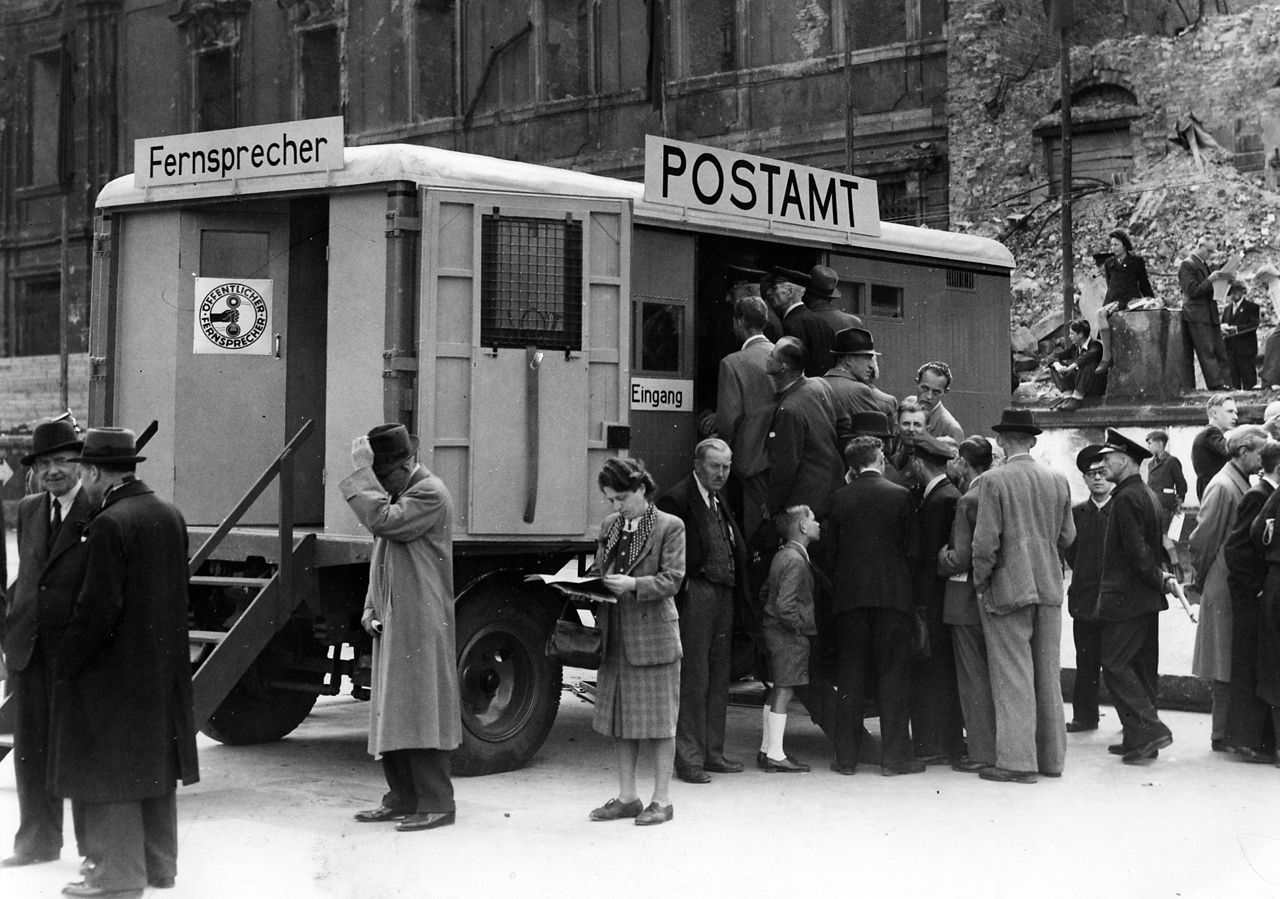 Historisches Bild Menschenmenge vor einem mobilen Postamt