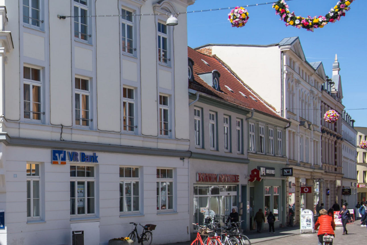 Ein weißes Eckhaus mit drei Etagen der VR Bank Mecklenburg eG in Güstrow