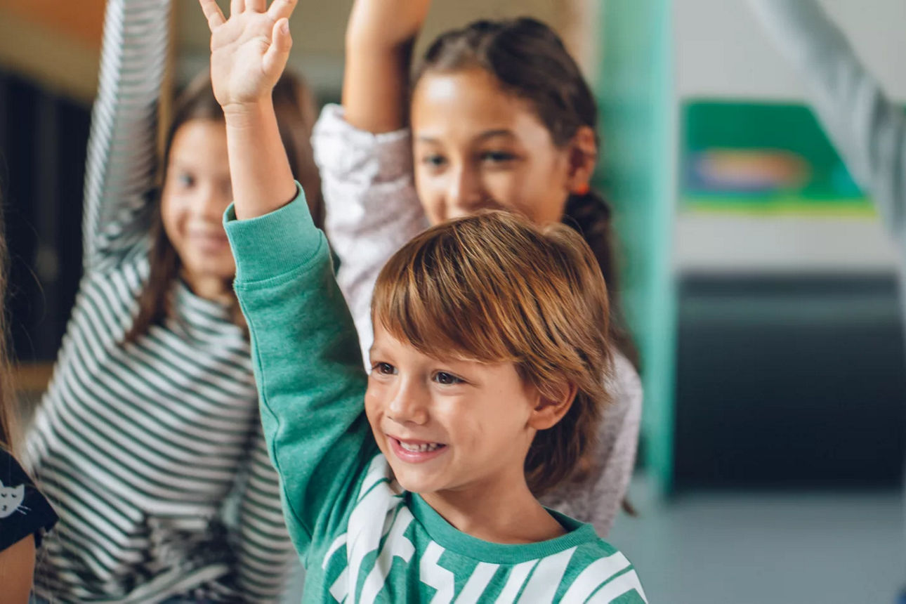 Kind meldet sich in einer Klasse