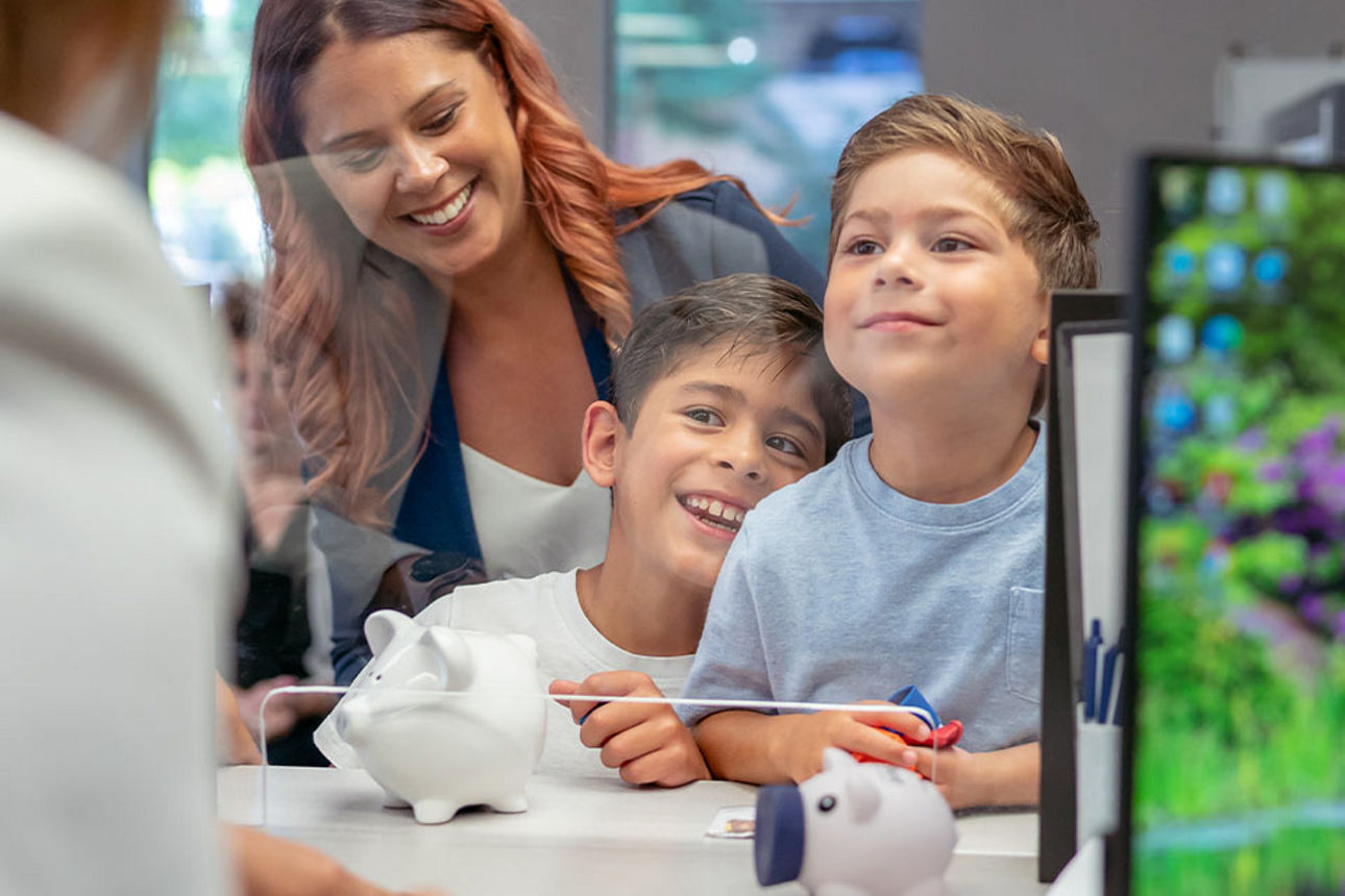 Zwei Kinder sind mit ihrer Mutter bei der Bank um ihr Erspartes einzuzahlen