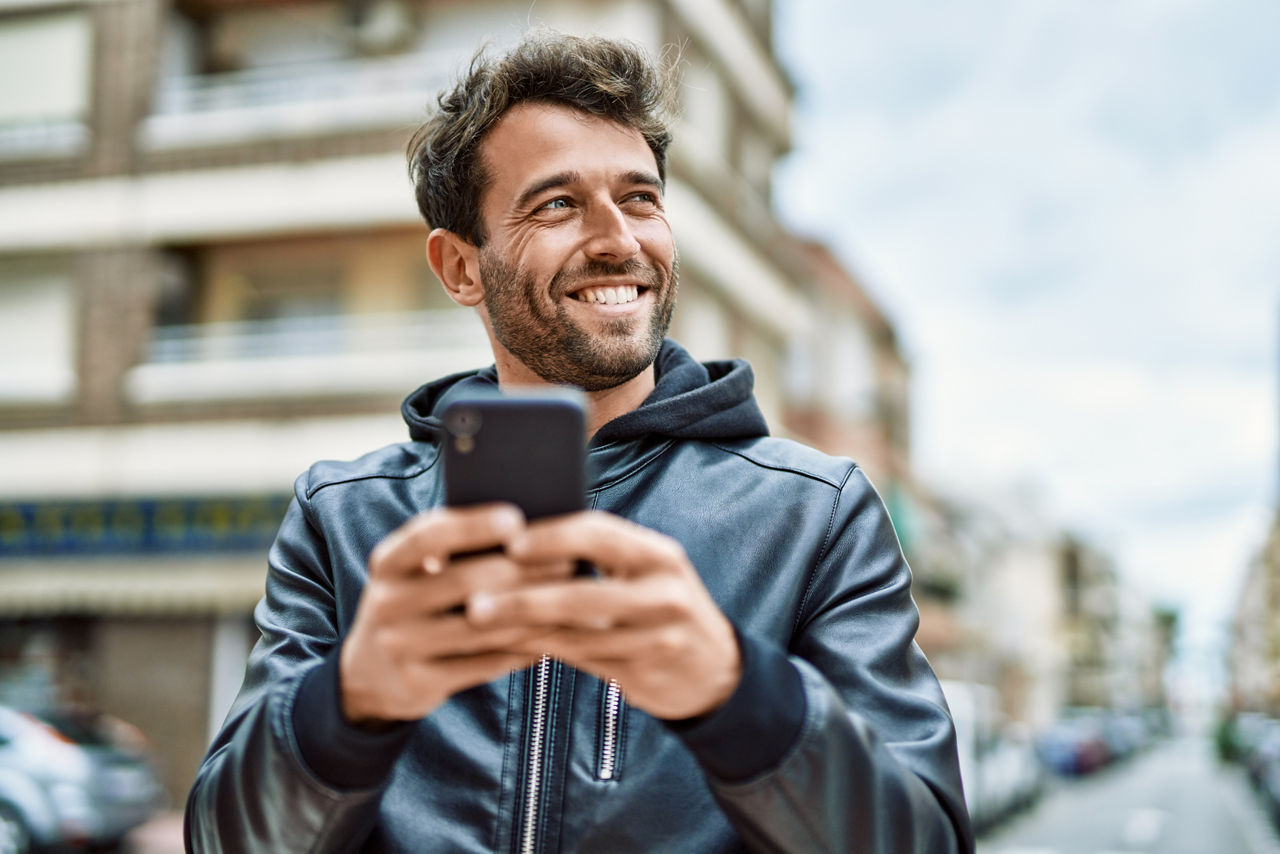 Mann hält Smartphone in urbaner Umgebung in der  Hand