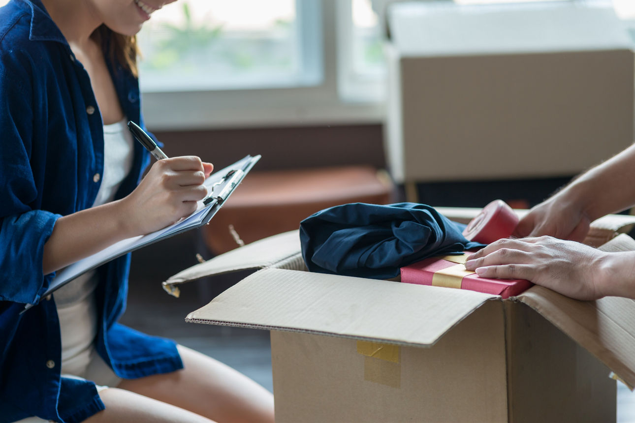 Ein junges Paar packt seine Sachen und überprüft diese anhand einer Checkliste, bevor es in sein neues Zuhause umzieht.