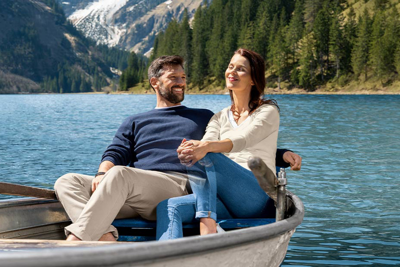 Ein Mann und eine Frau sitzen gemeinsam im Boot und lächeln 