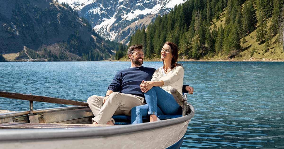 Mann und Frau sitzen in einem kleinen Boot auf dem Wasser 