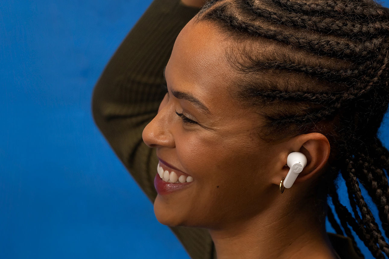 Glückliche Frau mit Kopfhörern im Ohr