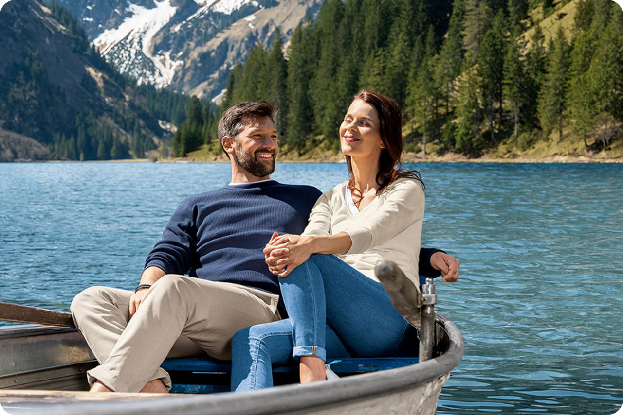 Ein Paar sitzt in einem Ruderboot und genießt die Sonne