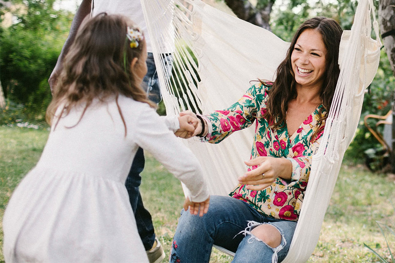 Frau sitzt auf einer Hängematte
