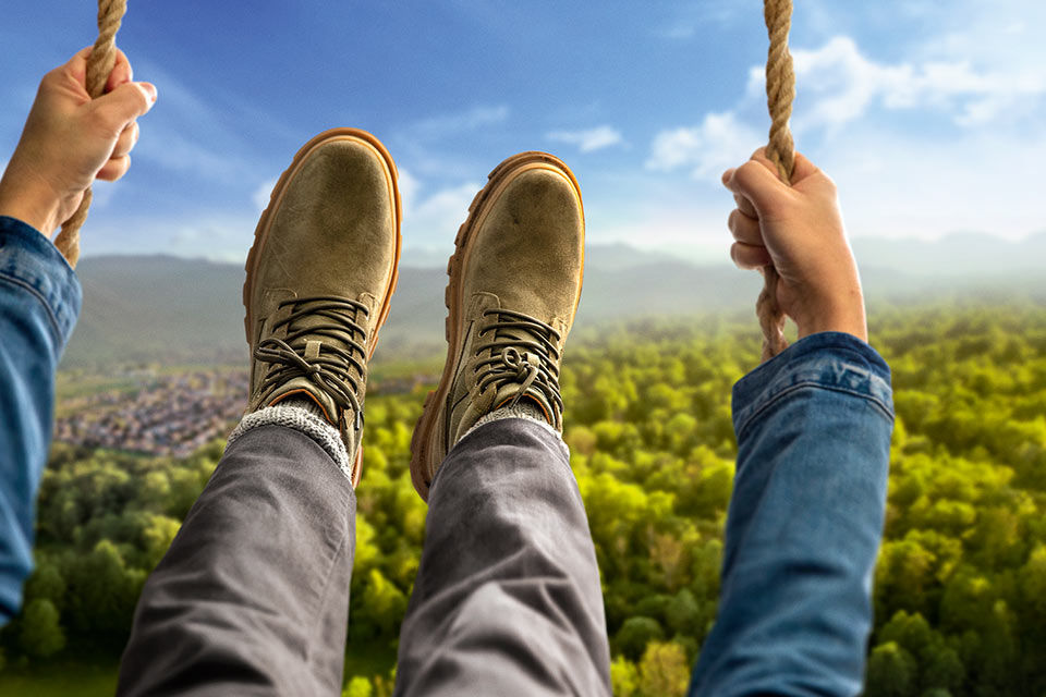 eine Person schaukelt über den Bäumen