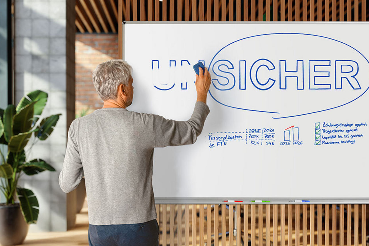 Mann schreibt auf einem Whiteboard